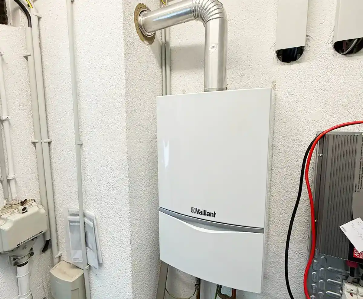 Wandhängende Vaillant Gasheizung mit Abgasrohr in einem Heizungsraum